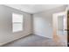 This bedroom features a large window for plenty of natural light and neutral-colored carpet at 1447 Honey Trl, Monroe, NC 28112