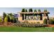 A welcoming community entrance sign with colorful landscaping and lush greenery at 1447 Honey Trl, Monroe, NC 28112