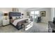 A spacious main bedroom with a large window, an upholstered headboard and neutral color palette at 1447 Honey Trl, Monroe, NC 28112