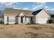 Tan house with a two-car garage, front porch and landscaping at 1630 Hardy Dr, Rock Hill, SC 29732