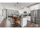 Open kitchen features white cabinetry, stainless appliances, a dark countertop and island seating at 1746 Blanche St, Charlotte, NC 28262