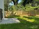 A newly fenced in backyard featuring a grass lawn and concrete patio area adjacent to the house at 211 Chestnut St, Shelby, NC 28150