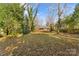 Spacious backyard with mature trees and a brick home in the background at 223 W 9Th St, Newton, NC 28658