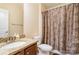 Clean bathroom with granite countertop, brown cabinets, and shower curtain at 2548 Flintshire Ln, Gastonia, NC 28056