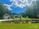 Gray farmhouse exterior with stone accents, landscaping, and a detached garage at 324 Patternote Rd, Mooresville, NC 28117