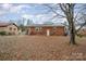 Brick home with a large backyard covered in leaves at 4201 Westridge Dr, Charlotte, NC 28208