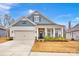 Two-story house with gray and beige siding, a front porch, and a two-car garage at 132 N Shayna Rd, Troutman, NC 28166