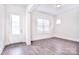 Bright empty room featuring hardwood floors, white trim, and a glass panel back door at 1364 Cedardale Ln, Denver, NC 28037