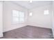 Neutral, empty room with hardwood flooring, white walls and trim, and plenty of natural light at 1364 Cedardale Ln, Denver, NC 28037