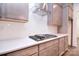 Close-up view of a kitchen with stainless steel cooktop, tile backsplash, and quartz counters at 1364 Cedardale Ln, Denver, NC 28037