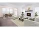 Inviting living room featuring a cozy fireplace, large windows for natural light, and an open view to the dining area at 1364 Cedardale Ln, Denver, NC 28037