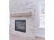 Stylish stone fireplace with wooden mantel, and adjacent window create a cozy and inviting atmosphere at 1374 Cedardale Ln # 33, Denver, NC 28037
