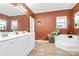 Bathroom with double vanity, corner tub, and terracotta-colored walls at 1485 Adkin Dr, Iron Station, NC 28080