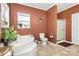 Bathroom with corner tub, shower, and terracotta-colored walls at 1485 Adkin Dr, Iron Station, NC 28080