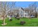 Charming two-story home with stone accents, well-maintained lawn, and mature trees at 1485 Adkin Dr, Iron Station, NC 28080