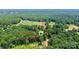 Aerial view of a home nestled in a large wooded lot outlined in red at 1769 Old Nc 27 Hwy, Mount Holly, NC 28120