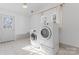 Bright laundry room with modern washer and dryer, white tile flooring, and exterior door at 1769 Old Nc 27 Hwy, Mount Holly, NC 28120