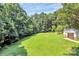 Expansive grassy lot surrounded by lush greenery and mature trees, near a small outbuilding at 1769 Old Nc 27 Hwy, Mount Holly, NC 28120