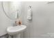 Small bathroom with pedestal sink and round mirror at 226 J.P. Dr, Albemarle, NC 28001