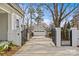 Gated driveway leading to a detached garage and home, framed by white brick pillars at 228 Heathwood Rd, Charlotte, NC 28211