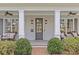 Inviting front porch featuring ceiling fans, stylish seating arrangements, and well-manicured shrubs leading to the main entrance at 228 Heathwood Rd, Charlotte, NC 28211