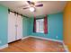 Bedroom featuring colorful walls, hardwood floors, barn door closet and window at 6726 Wannamaker Ln, Charlotte, NC 28226