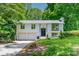 Charming split-level home featuring a two-car garage and updated black trim windows, nestled in a lush, green setting at 6726 Wannamaker Ln, Charlotte, NC 28226