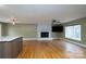 Open-concept living area with hardwood floors, a white brick fireplace, and large windows at 6726 Wannamaker Ln, Charlotte, NC 28226
