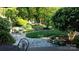 Backyard with stone path, lush landscaping, and seating area at 10439 Donahue Dr, Huntersville, NC 28078