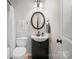 Clean bathroom with dark vanity, round mirror, and updated fixtures at 10439 Donahue Dr, Huntersville, NC 28078