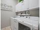 Bright laundry room with white cabinets and modern washer/dryer at 10439 Donahue Dr, Huntersville, NC 28078