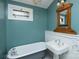 Bathroom with pedestal sink, clawfoot tub, and vintage mirror at 106 N Battleground Ave, Kings Mountain, NC 28086