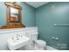 Bathroom with pedestal sink, toilet and vintage mirror at 106 N Battleground Ave, Kings Mountain, NC 28086