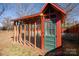 Rustic red chicken coop with green door in the backyard at 106 N Battleground Ave, Kings Mountain, NC 28086