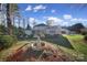 Expansive backyard featuring a fountain, lush greenery, and a glimpse of the beautiful home at 115 Amelia Ln, Mooresville, NC 28117