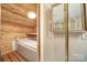 A sauna room with wood paneling, white tiled floor, and a glass-enclosed shower at 115 Amelia Ln, Mooresville, NC 28117