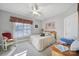 Cozy bedroom with neutral walls, ceiling fan, a patterned bedspread, and a white rocking chair at 115 Amelia Ln, Mooresville, NC 28117