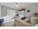 Bright bedroom with neutral walls, a ceiling fan, white closet doors, and plenty of natural light at 115 Amelia Ln, Mooresville, NC 28117