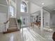 Bright foyer with soaring ceilings, elegant staircase, and lots of natural light shining on the tile floor at 115 Amelia Ln, Mooresville, NC 28117