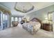 Large main bedroom with a tray ceiling, fireplace, sitting area, and neutral decor at 115 Amelia Ln, Mooresville, NC 28117