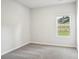 Cozy bedroom with neutral carpet, white walls, and a window overlooking a hillside at 115 Obadiah Ct, Troutman, NC 28115