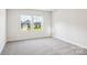 Bright bedroom with neutral carpet and a view of a neighboring house through two windows at 115 Obadiah Ct, Troutman, NC 28115