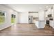 Open floor plan showcasing the kitchen with stainless appliances and living area with wood floors at 115 Obadiah Ct, Troutman, NC 28115