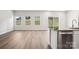 Open-concept living area with wood floors, multiple windows, and a view of the backyard at 115 Obadiah Ct, Troutman, NC 28115
