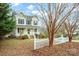 Two-story house with light-yellow siding, shutters, and a white picket fence at 119 Heritage Creek Dr, Hickory, NC 28601