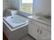 This stylish bathroom features dual sinks and a large soaking tub with windows at 13312 Chopin Ridge Rd, Huntersville, NC 28078