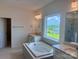 Bathroom featuring a soaking tub, walk-in shower, and a bright window with a scenic view at 13312 Chopin Ridge Rd, Huntersville, NC 28078