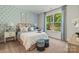 Charming bedroom featuring a stylish bed, blue accent wall, and a large window with green views at 13312 Chopin Ridge Rd, Huntersville, NC 28078