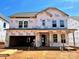 New construction home with a Tyvek wrapped exterior, showcasing a modern design and a two car garage at 13312 Chopin Ridge Rd, Huntersville, NC 28078