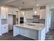 Bright kitchen features white cabinets, stainless appliances, and a large island with pendant lighting at 13312 Chopin Ridge Rd, Huntersville, NC 28078